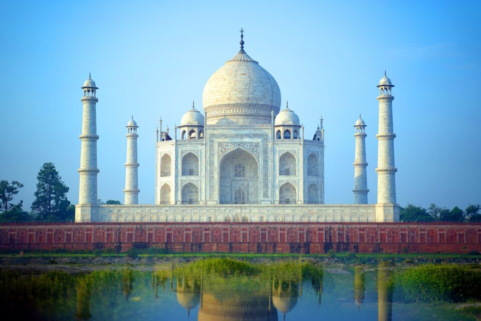 Taj Mahal w blasku zachodu słońca, odbijający się w spokojnej wodzie, symbol miłości.