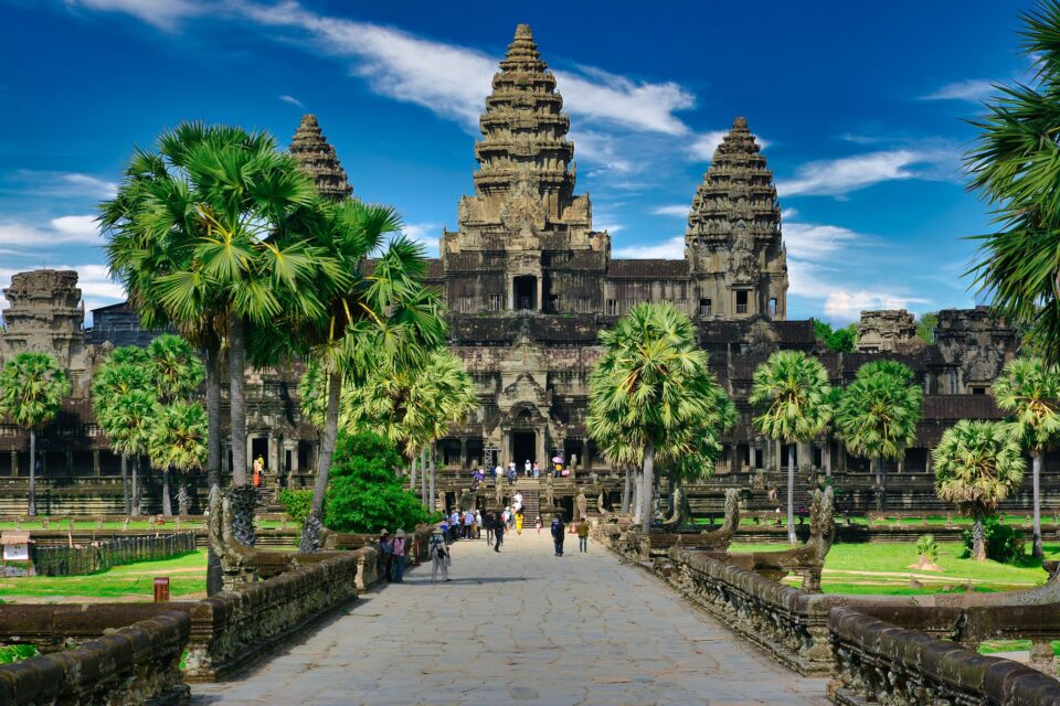Angkor Wat z turystami w tle, zachwycająca architektura i bujna zieleń wokół.